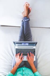vrouw op bed met laptop